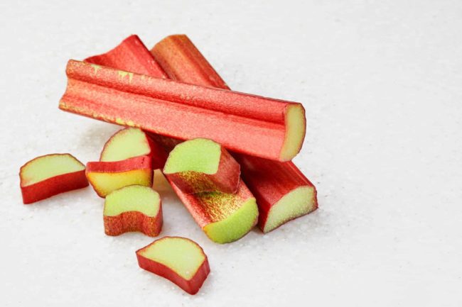 tranches-tige-rhubarbe-fond-marbre-blanc-batonnets-rhubarbe-entiers-quelques-morceaux-rhubarbe-hachee-ingredients-isoles-pour-faire-tarte